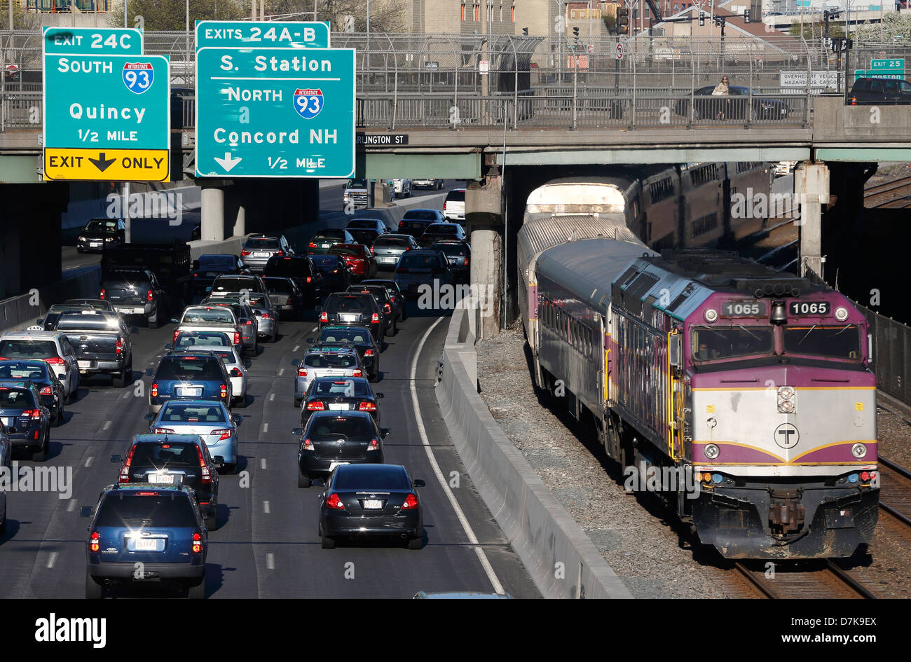 Le vetture in Massachusetts Turnpike estensione e un commuter rail lasciando in treno Stazione Sud di Boston, Massachusetts Foto Stock