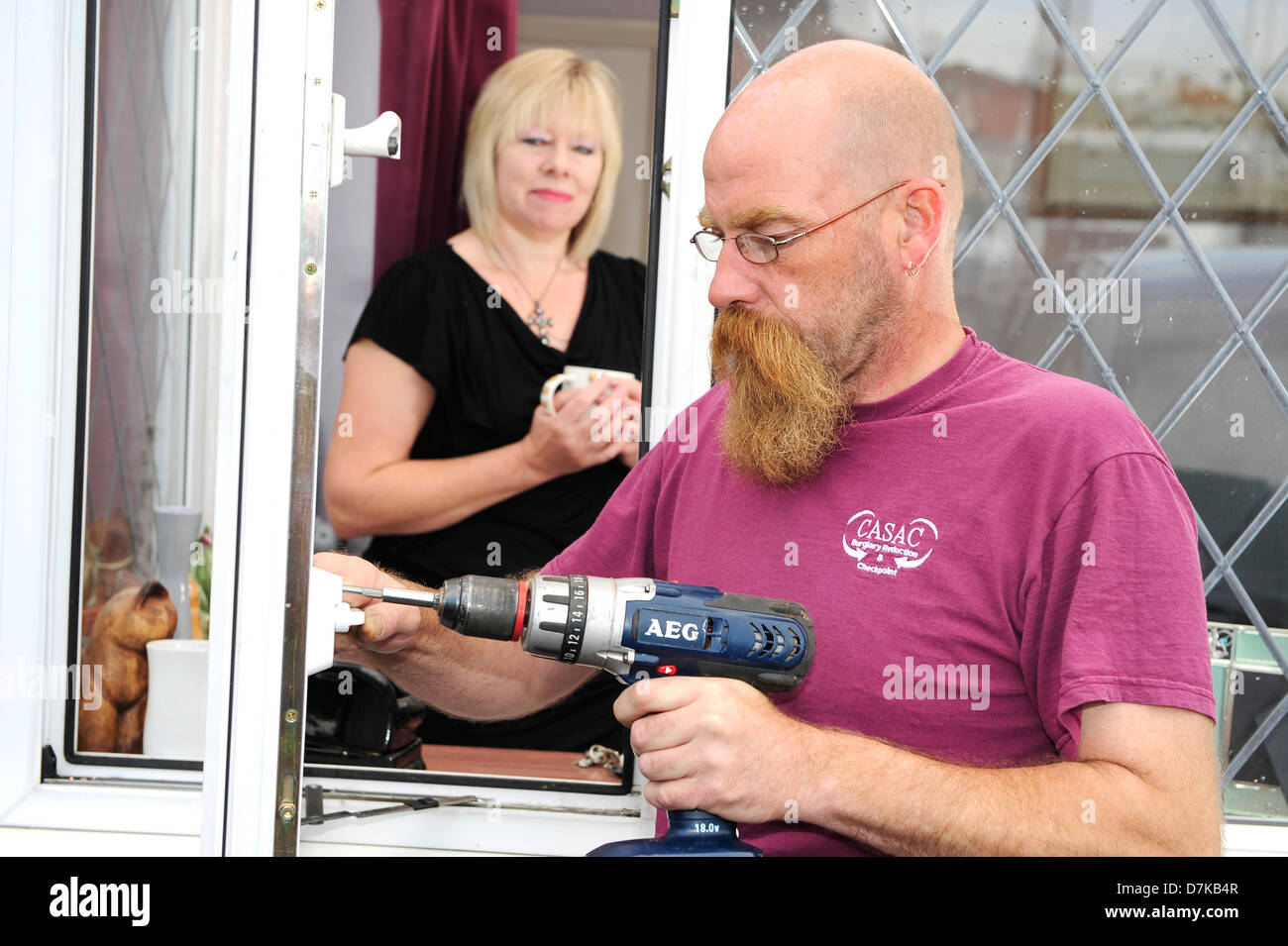 Un fabbro un raccordo di bloccaggio per una finestra di una finestra di un proprietario di casa a Leeds, West Yorkshire. Foto Stock