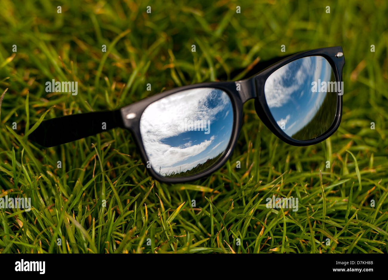 Belle blue skies riflesso in una coppia di mirroring di wayfarer occhiali da sole per rappresentare estate Foto Stock