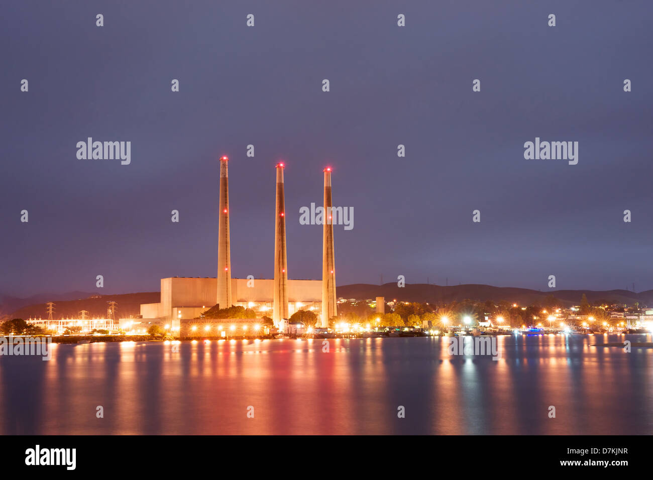 Centrale elettrica illumina con la luce della notte su una baia. Foto Stock