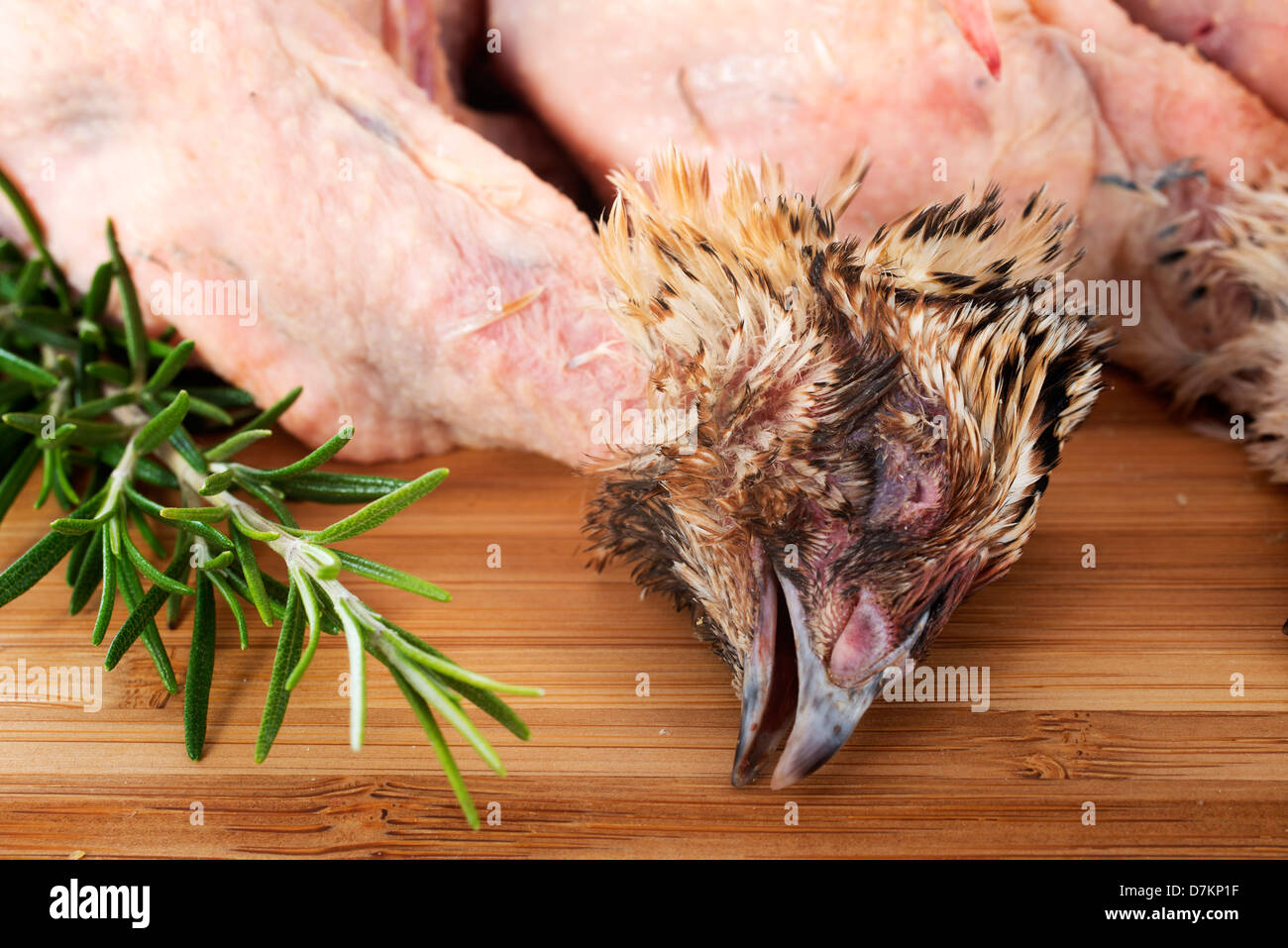 Quaglia carcasson un tagliere con rosmarino Foto Stock