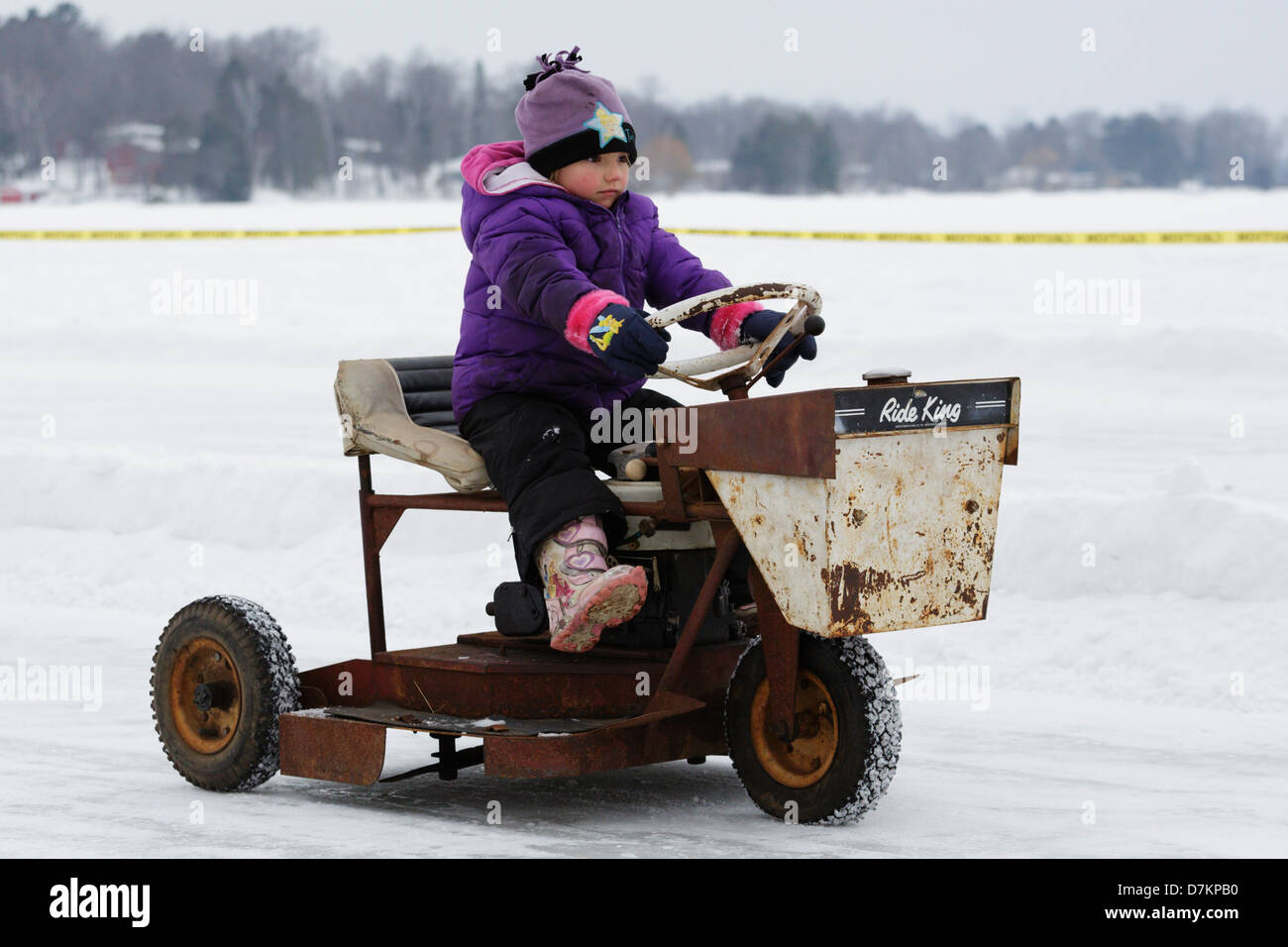 Giovane pilota un vecchio vintage tosaerba durante un pre-event parade prima che la prima relazione annuale di tosaerba gare di ghiaccio sul lago di coltello. Foto Stock