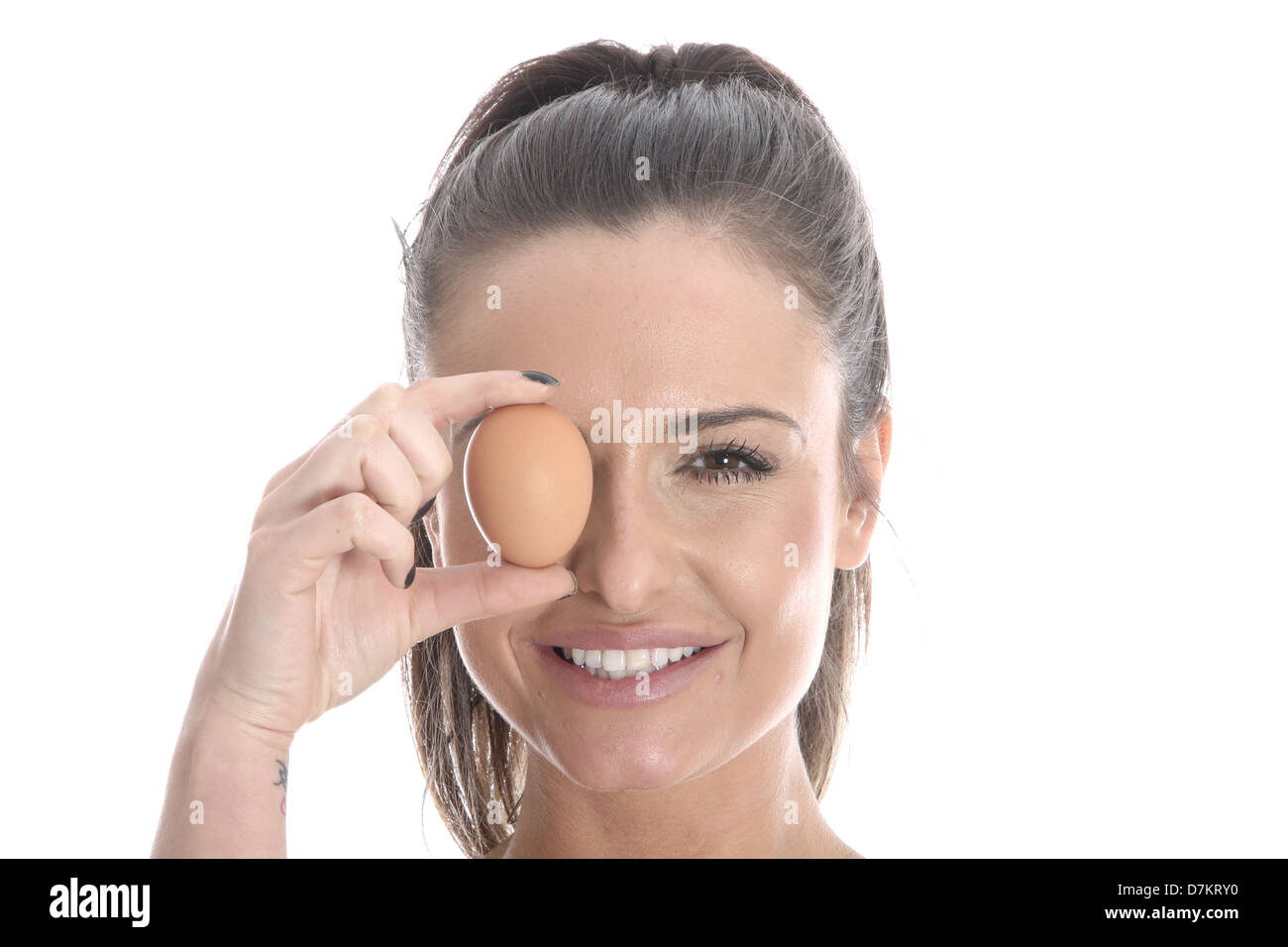Modello rilasciato. giovane donna in possesso di un uovo marrone Foto Stock
