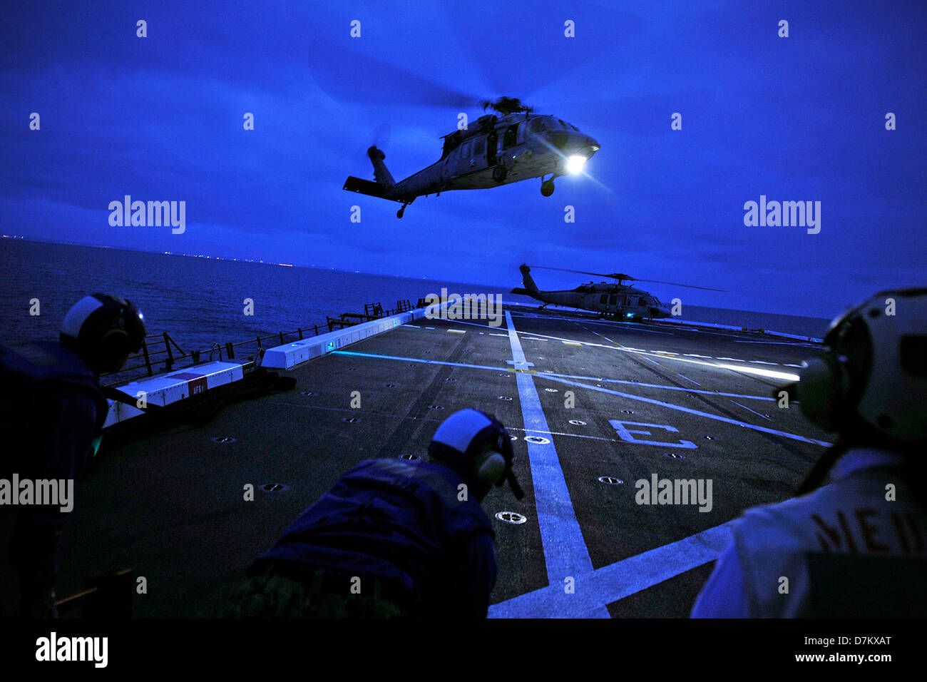 Un US Navy MH-60S Seahawk elicottero si avvicina il ponte di volo del trasporto anfibio dock nave USS New Orleans durante la notte le operazioni di volo il 30 aprile 2013 nell'Oceano Pacifico. Foto Stock