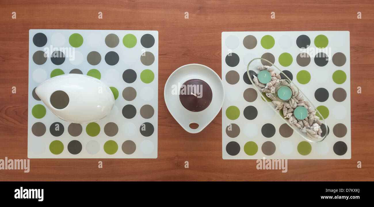 Avvistato tappetini e candele sui tavoli da caffè in legno Foto Stock