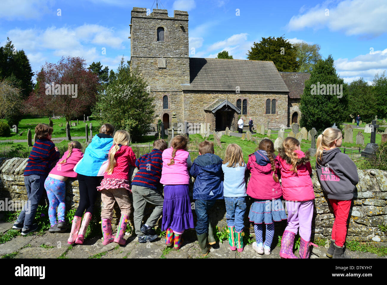 I bambini si appoggia sulla parete di Stokesay Castle, che mostra San Giovanni Battista, Stokesay, Shropshire, England, Regno Unito Foto Stock