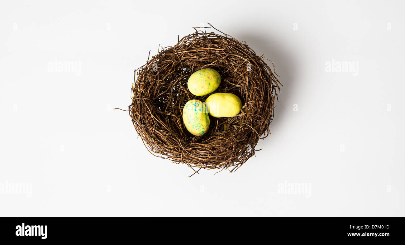 Un nido di uccello giallo le uova in un nido. Pasqua di cioccolato candy. Isolato su bianco. Foto Stock