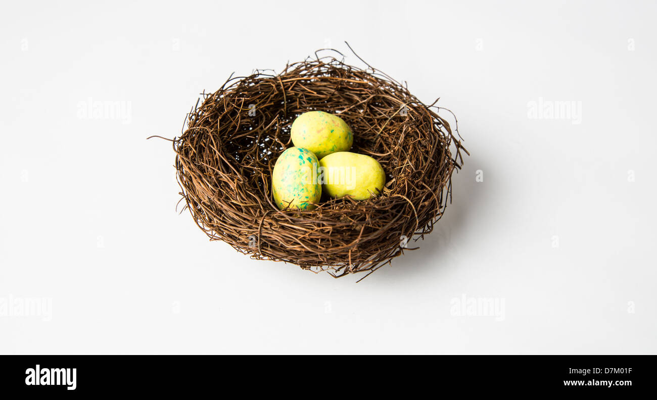 Un nido di uccello giallo le uova in un nido. Pasqua di cioccolato candy. Isolato su bianco. Foto Stock