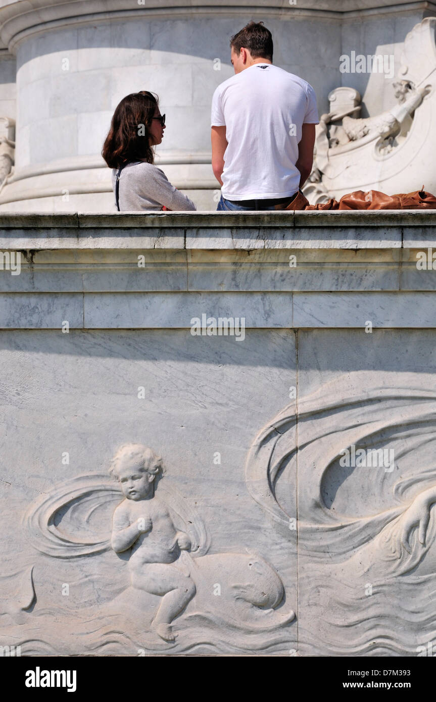 Londra, Inghilterra, Regno Unito. Coppia giovane alla base del memoriale della Victoria di fronte a Buckingham Palace Foto Stock