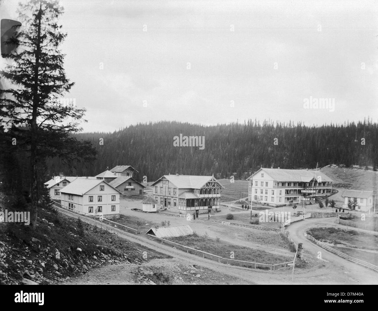 Il Sanatorium Tonsåsen, situato a Valdres, Norvegia, è mostrato in questa fotografia storica. Adagiato sullo sfondo di una foresta con alberi di conifere e una strada rurale, riflette l'architettura scandinava dell'inizio del XX secolo e le strutture sanitarie. Foto Stock