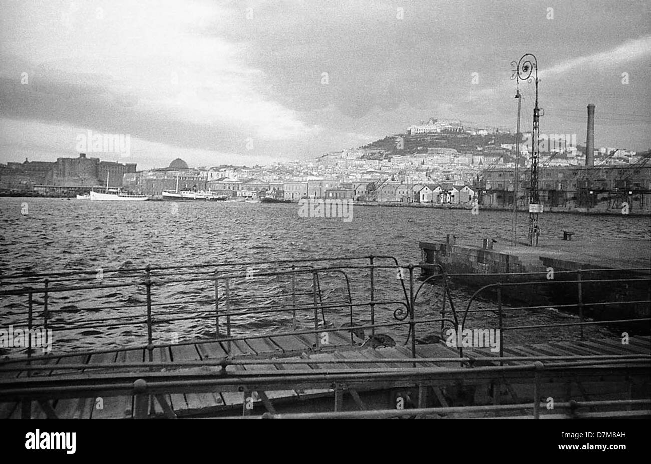 Questa fotografia d'epoca offre una vista di Napoli, Italia, che mostra il paesaggio caratteristico, l'architettura e la bellezza costiera della città. Napoli è conosciuta per i suoi siti storici e la sua vivace cultura. Foto Stock