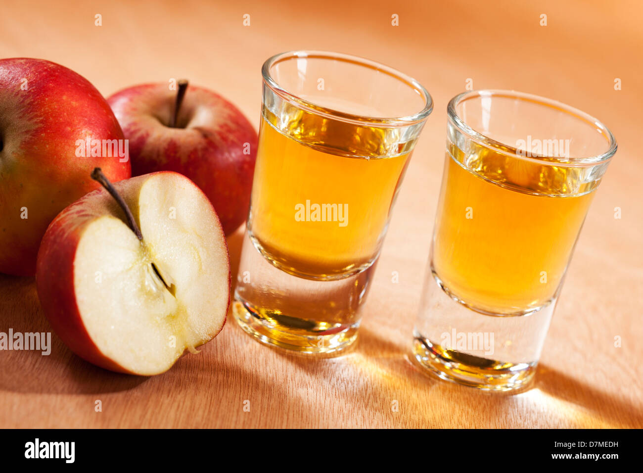 Due bicchieri di grappa alla mela e le mele rosse, vista inclinato Foto Stock