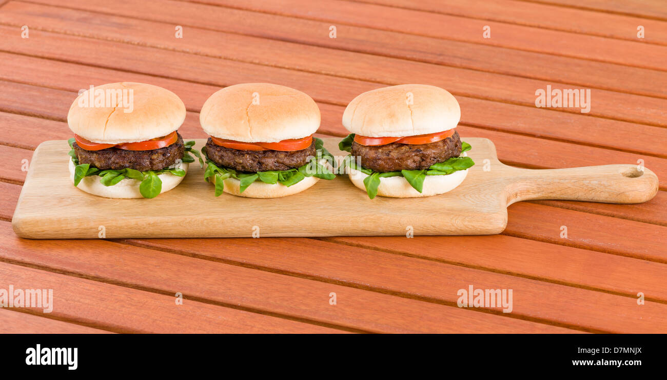 Hamburger - hamburger in bianco panini con estate e foglia di pomodoro. Foto Stock
