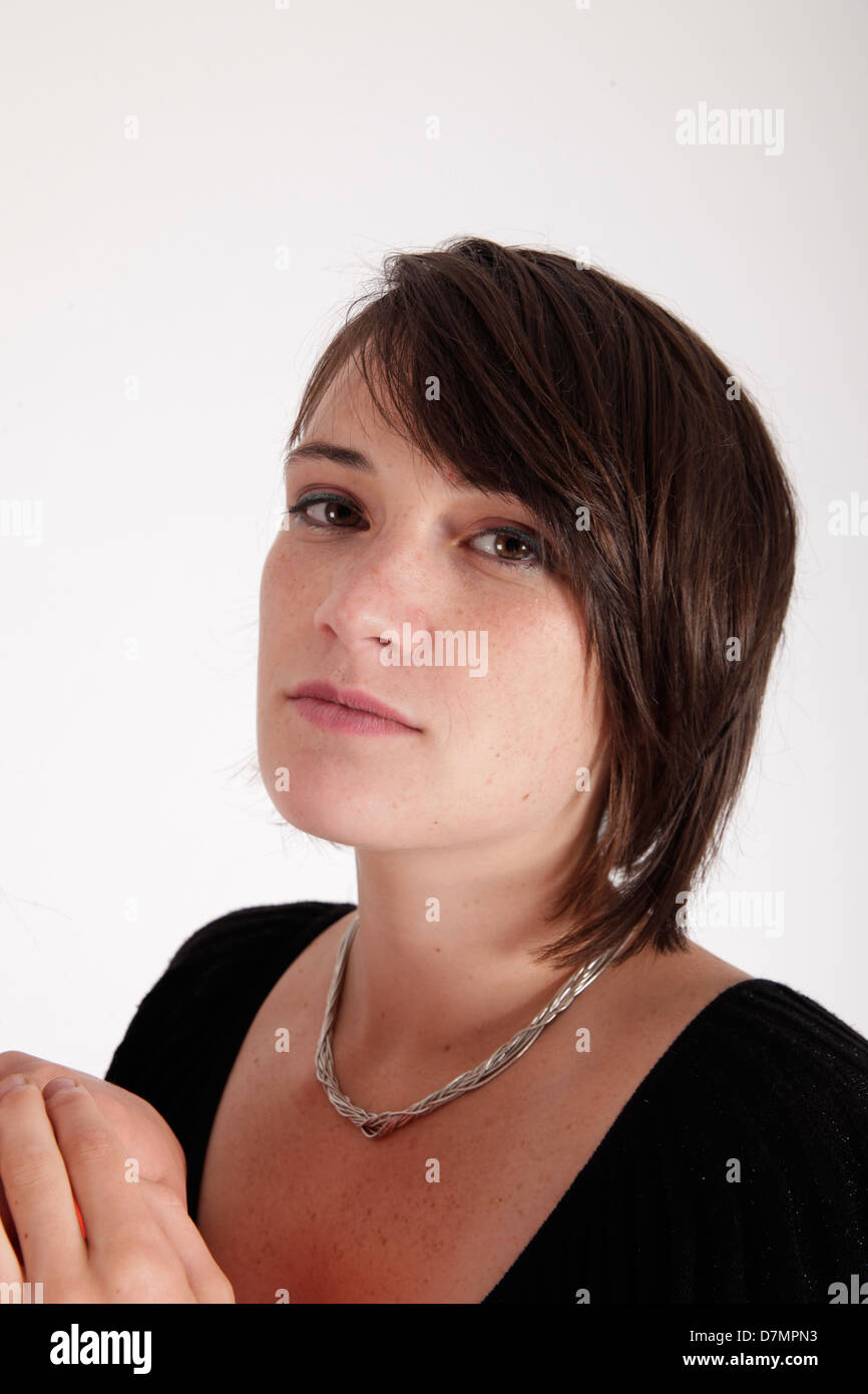 Variazione espressione sul viso di una giovane donna bruna in studio Foto Stock