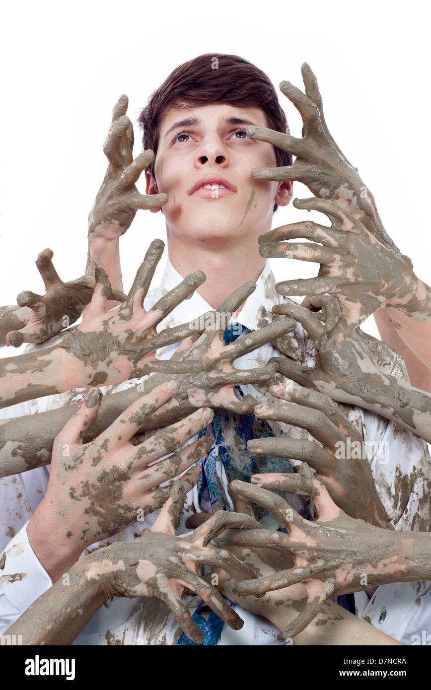 Giovane uomo cercando macchiata dalla moltitudine di mani sporche Foto Stock