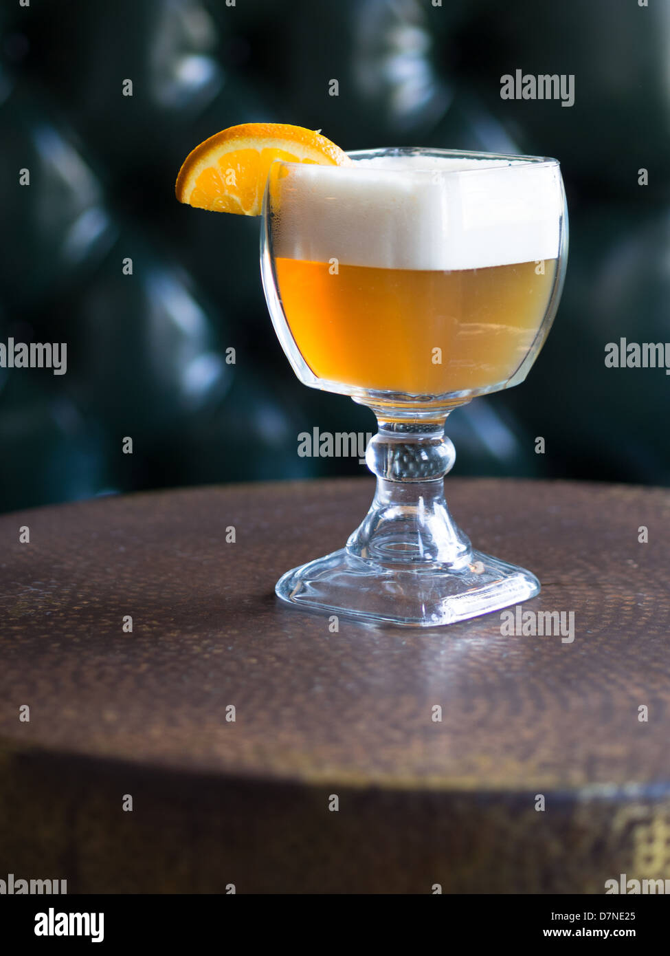 Un bicchiere pieno di hefeweizen (birra di grano) con un arancione sul cerchione Foto Stock