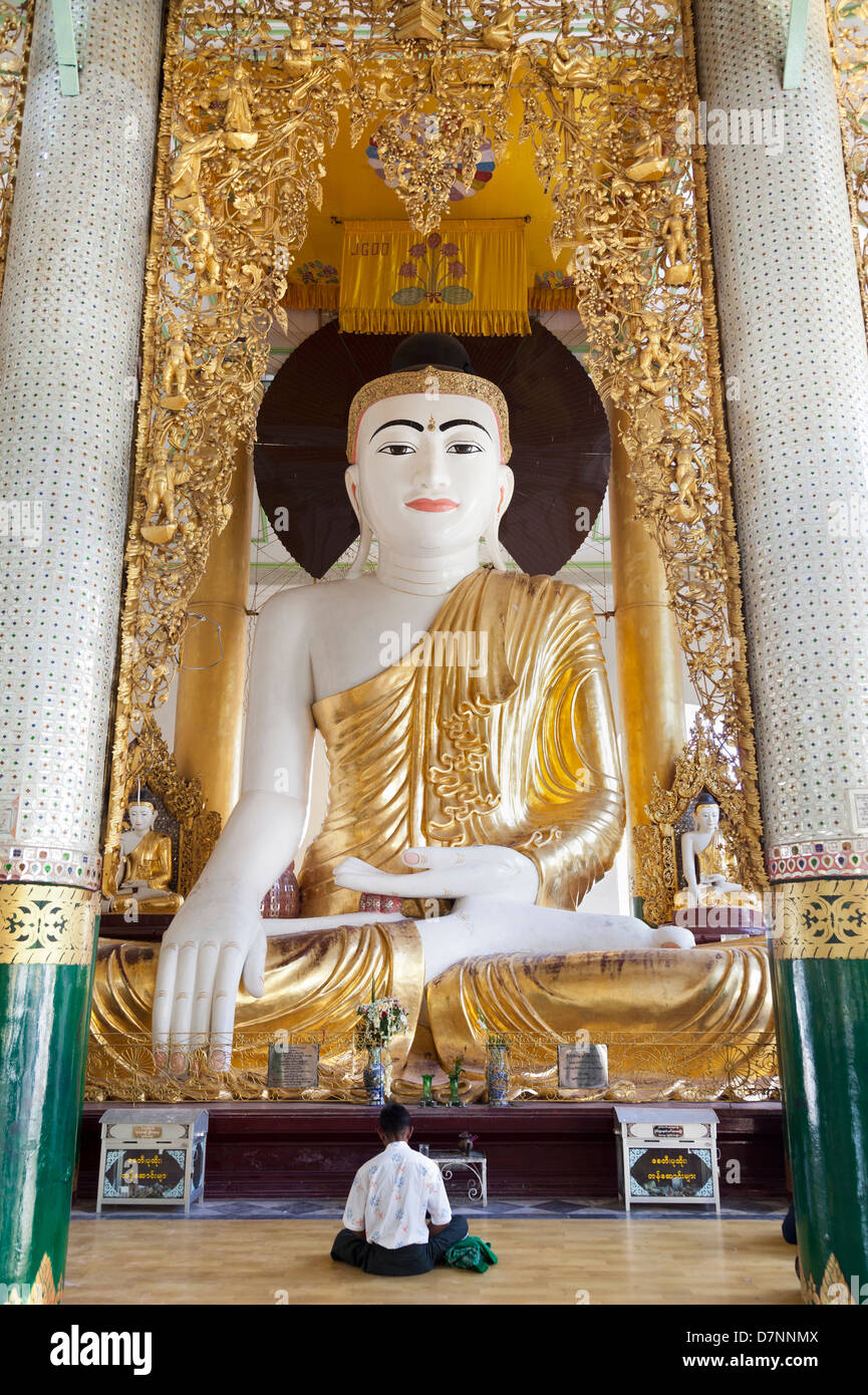 Uomo che prega al Grande Buddha seduto alla Shwedagon pagoda in Yangon, Myanmar 2 Foto Stock