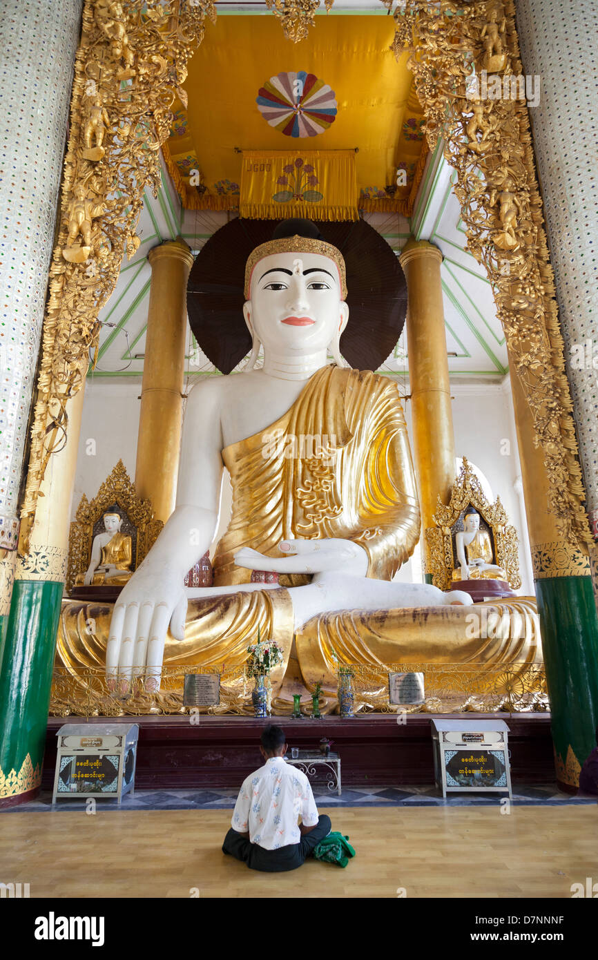 Uomo che prega al Grande Buddha seduto alla Shwedagon pagoda in Yangon, Myanmar 1 Foto Stock
