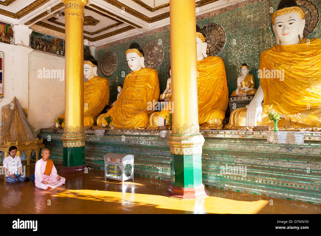 Nun e donna che prega prima di Buddha in Shwedagon pagoda Yangon Myanmar 1 Foto Stock