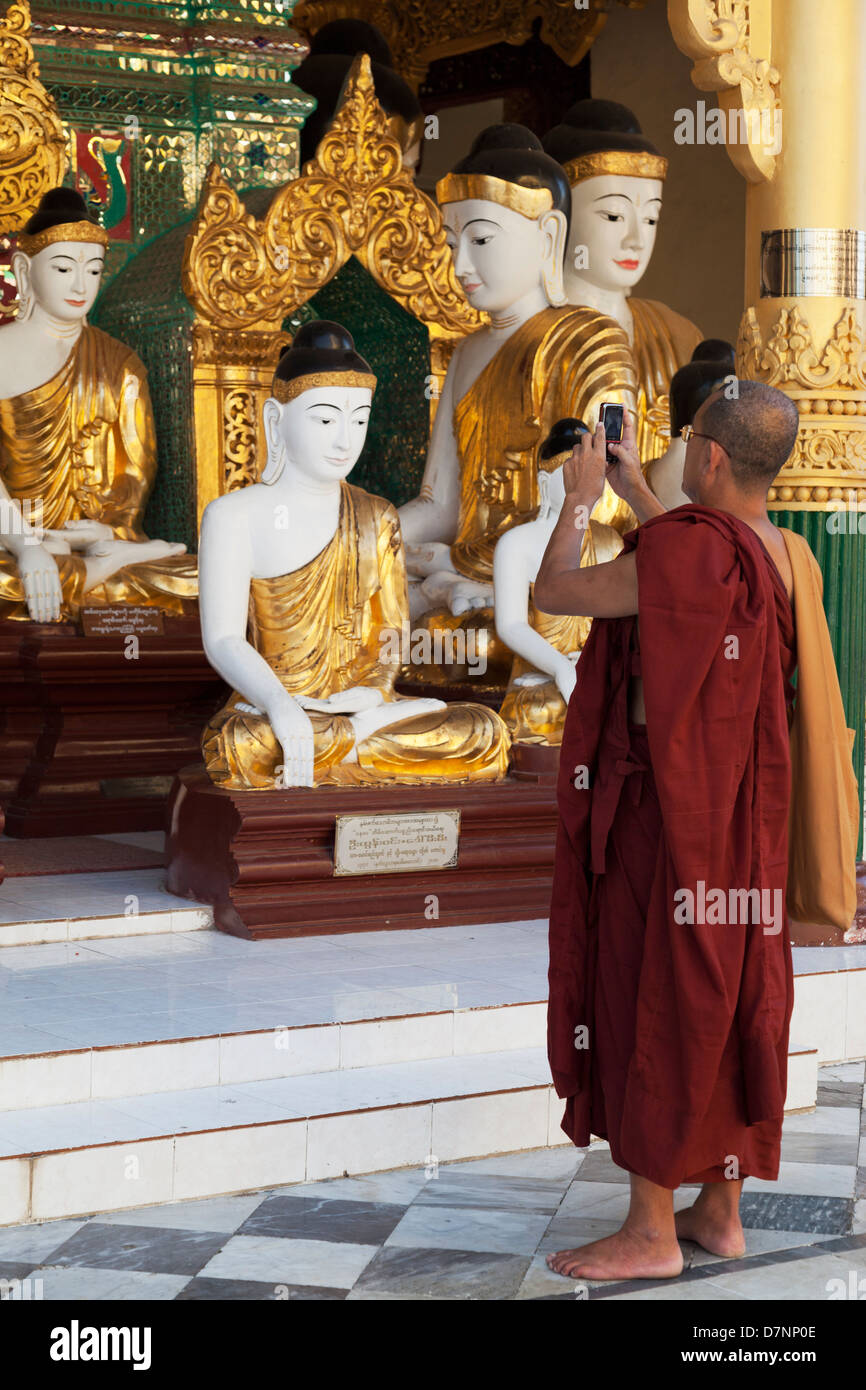 Vecchio e nuovo - Monaco buddista con la fotocamera del telefono in Shwedagon pagoda Yangon Myanmar Foto Stock
