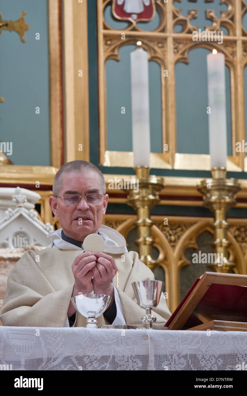 Un prete cattolico con la santa Eucaristia Foto Stock