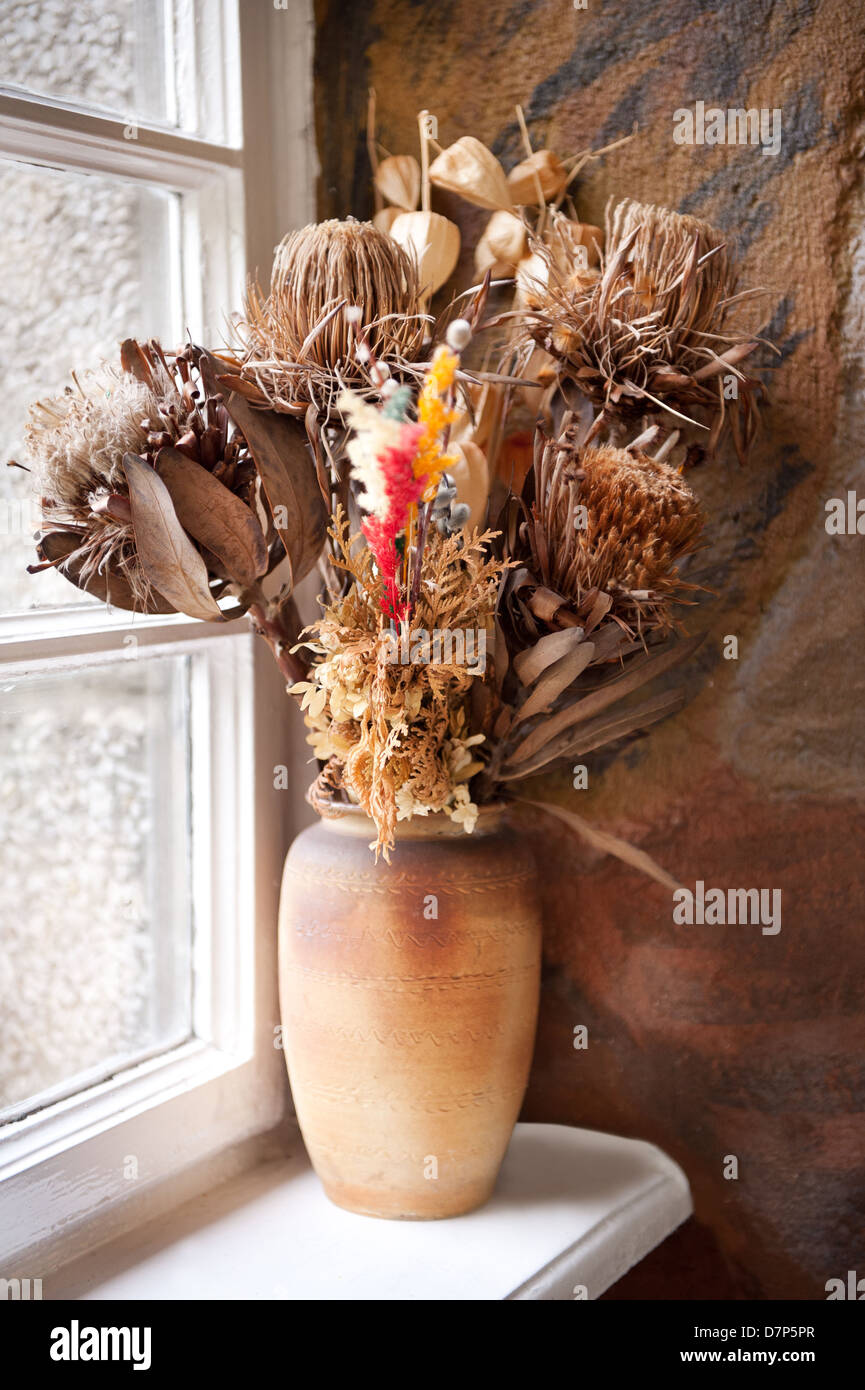 Mazzo di fiori secchi nel vaso marrone sul davanzale Foto Stock
