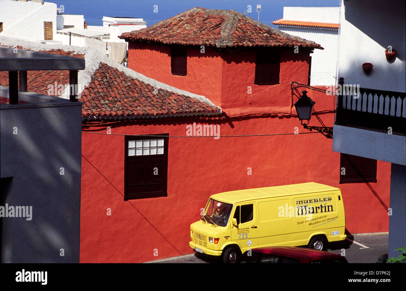 Giallo van parcheggio accanto ad una parete rossa sulla strada a Icod de los Vinos Foto Stock