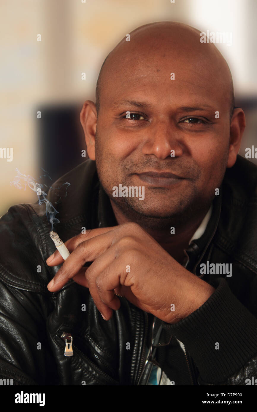 South Asian fumatore sorridente Foto Stock