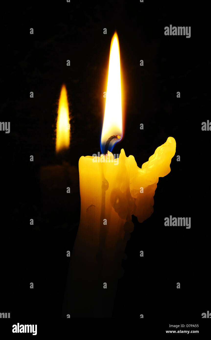 Candela bianca con la cera in esecuzione sul lato in basso a lume di candela con la riflessione su sfondo nero. Foto Stock