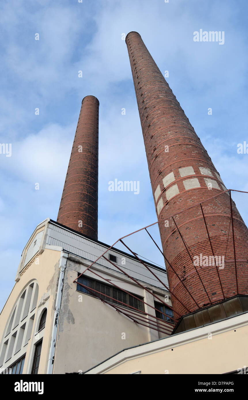 Edificio industriale e due mattone camino contro il cielo blu Foto Stock