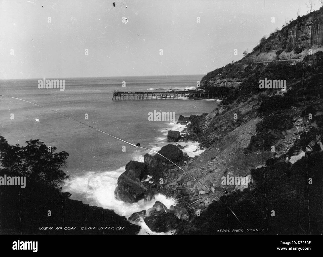 Una fotografia storica che raffigura la vista vicino al molo di Coal Cliff, catturando il paesaggio naturale costiero e le infrastrutture dell'epoca. Foto Stock