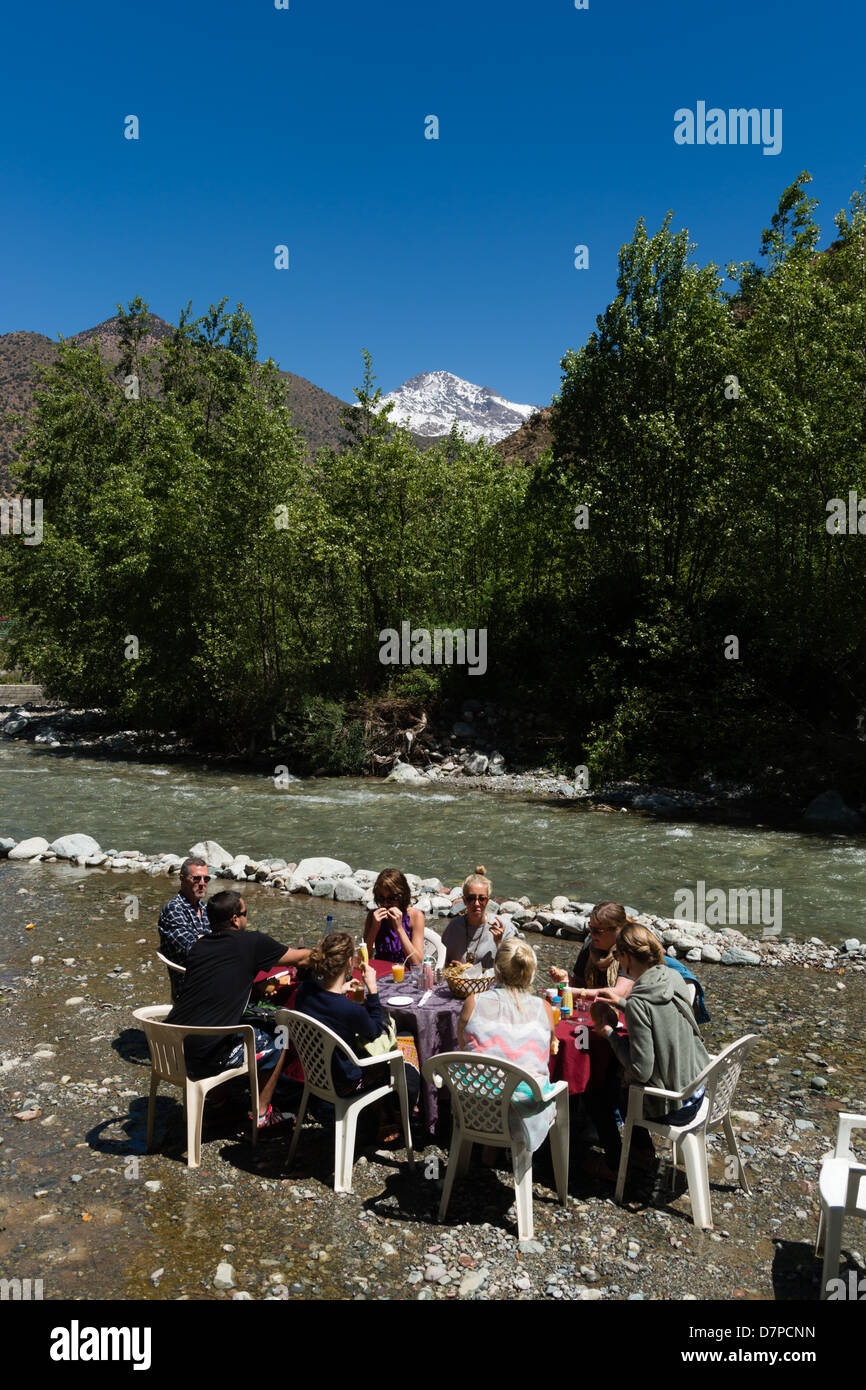 Il Marocco, Marrakech - Sti Fatma, Ourika Valley - famiglia a pranzare in una tabella di destra accanto al fiume. Foto Stock