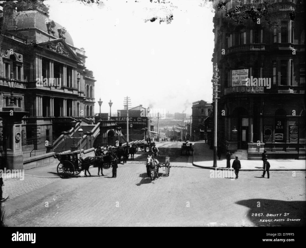 Una vista storica di Druitt Street nel centro di Sydney, che cattura la Centennial Hall e il vicino Gresham Hotel. La fotografia mette in risalto la vivace scena di strada con carrozze e aziende, sullo sfondo del municipio di Sydney. Foto Stock