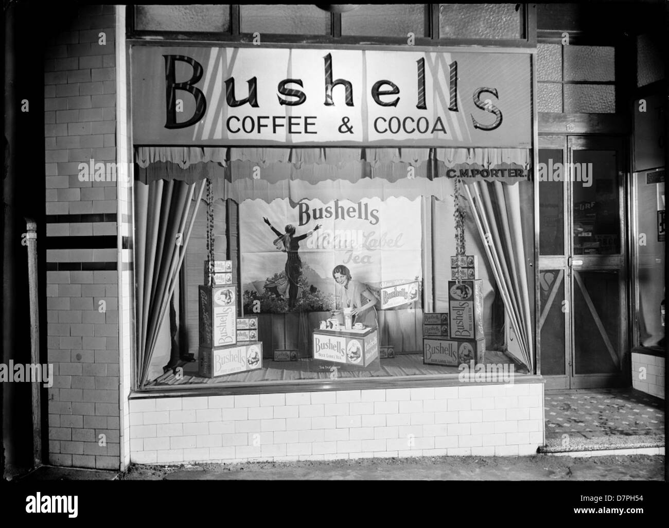 Questa immagine mostra un negozio vintage del negozio di C.M. Porter, con scatole da caffè Bushells. La fotografia cattura un'epoca di commercio all'inizio del XX secolo, mostrando prodotti iconici australiani come il tè e il caffè Bushells, parte della collezione del Powerhouse Museum. Foto Stock