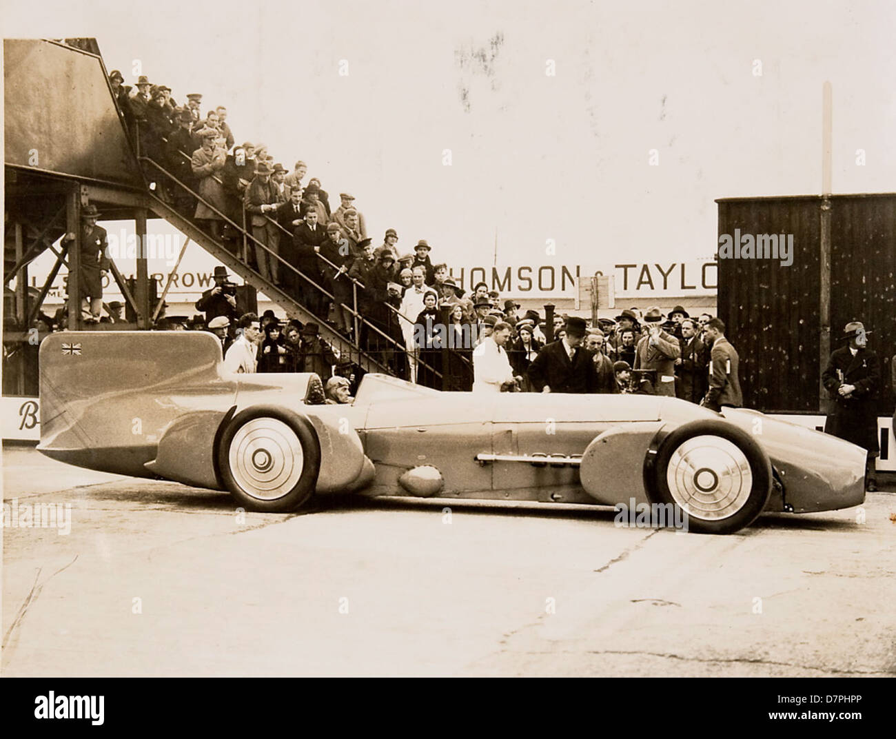 Questa fotografia storica mostra Sir Malcolm Campbell al volante del suo famoso veicolo Bluebird durante un tentativo di record di velocità terrestre negli anni '1920 o '1930 La folla circonda il veicolo, sottolineando l'interesse pubblico e l'eccitazione che circondano le prove di velocità di Campbell in Australia. Foto Stock