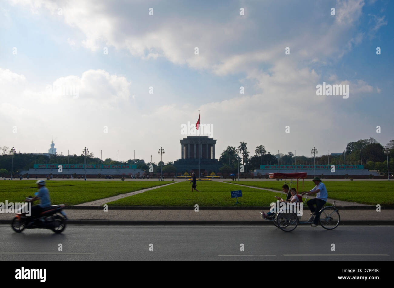 Paesaggio urbano orizzontale di ciclomotori e moto la guida ha superato il Mausoleo di Ho Chi Minh nel centro di Hanoi in una giornata di sole. Foto Stock