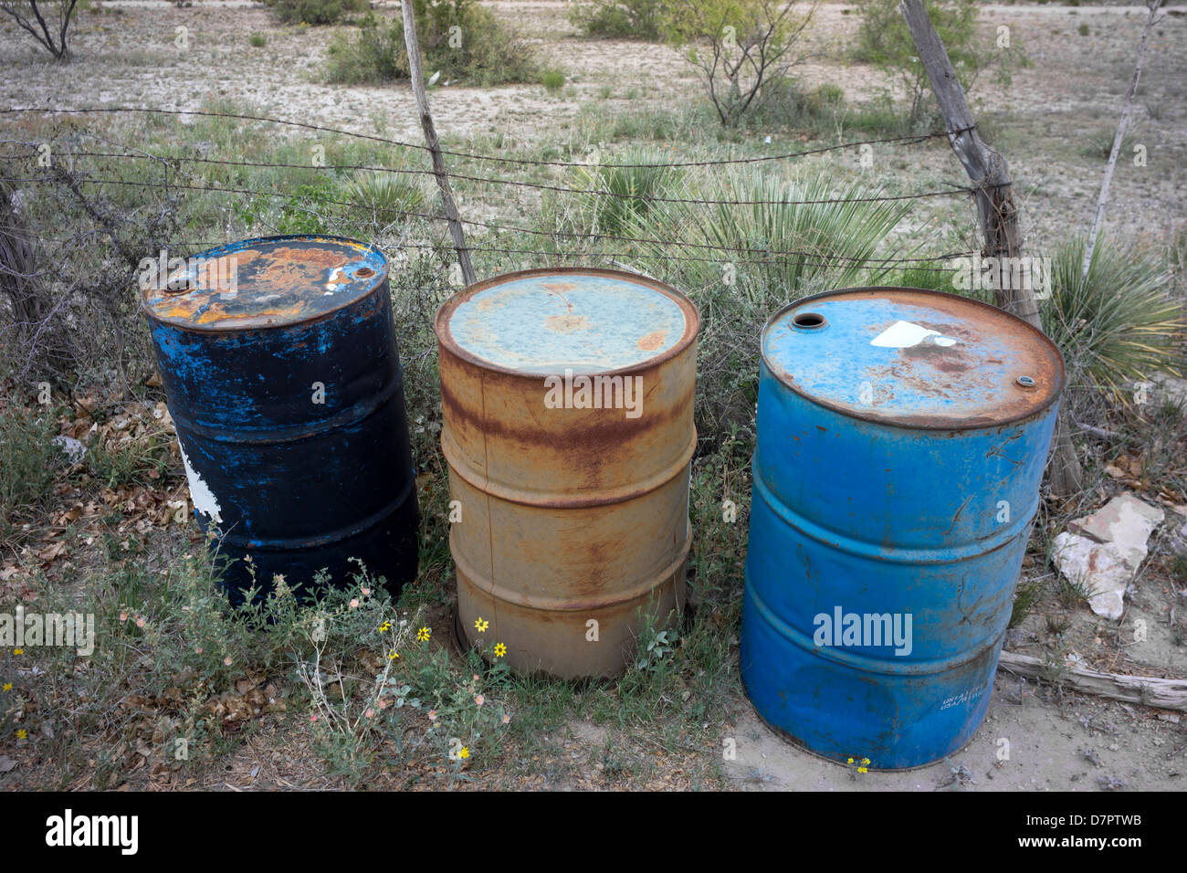 I fusti di olio sono state abbandonate da un lato di una strada ad ovest del Texas. Foto Stock