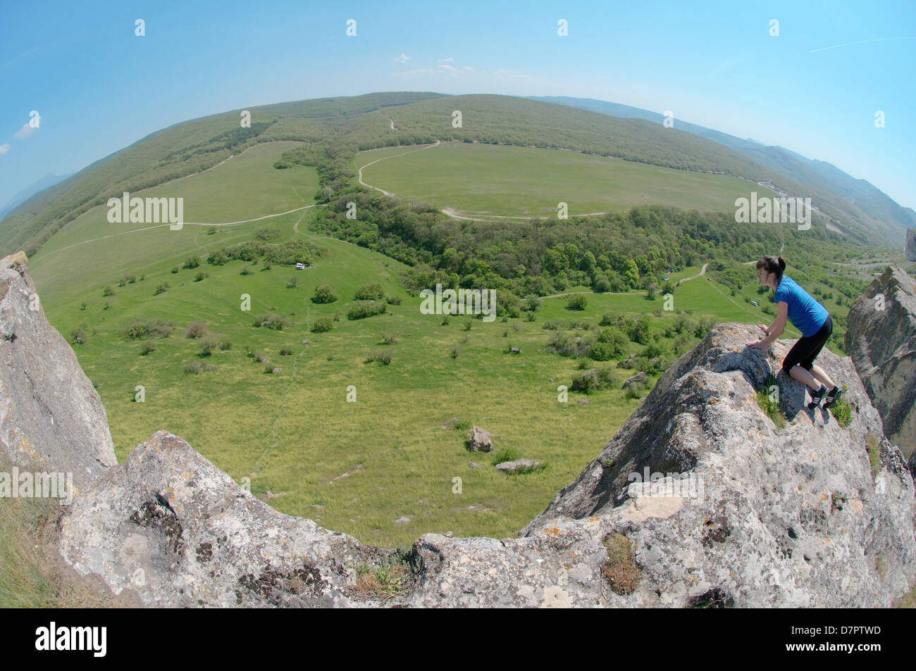 Una donna guarda giù dalla scogliera. Montagne della Crimea in Crimea, Ucraina, Europa orientale Foto Stock