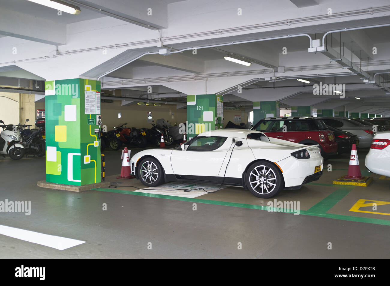dh Electric punto di ricarica TRASPORTO ASIA Cina Tesla Roadster auto in Hong Kong parcheggio ricarica stazione auto collegata ev carica Foto Stock