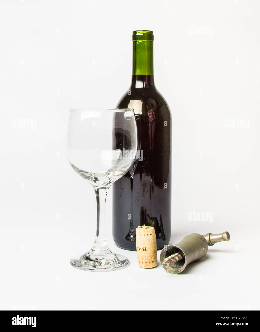 Una bottiglia di vino rosso, vuoto bicchiere di vino e un cavatappi su uno sfondo bianco. Foto Stock