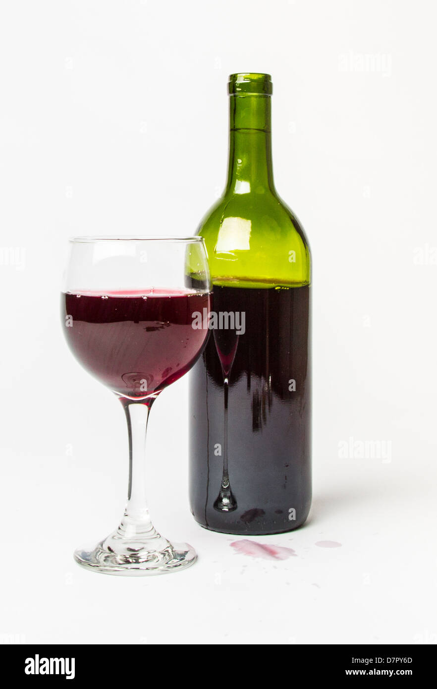 Un bicchiere pieno di vino rosso con la bottiglia e colorate sullo sfondo bianco. Foto Stock