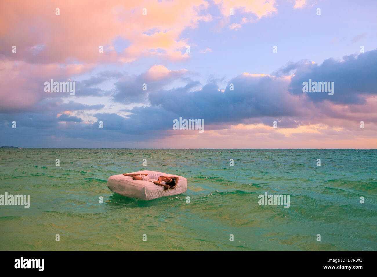 La donna nel suo letto alla deriva in mare Foto Stock