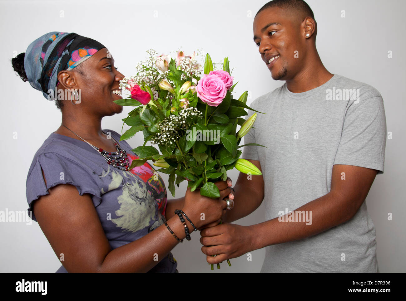 Cresciuto figlio dando la sua mamma fiori Foto Stock
