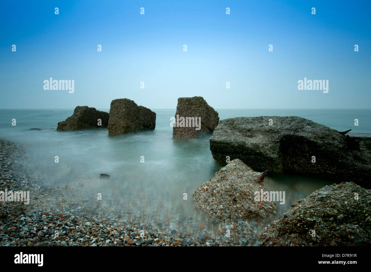 Una lunga esposizione di massi di cemento in mare Foto Stock