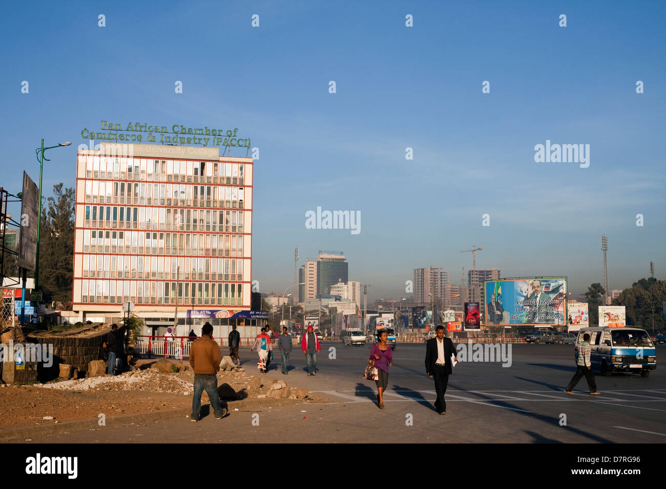 La gente che camminava per lavorare poco dopo l'alba attraverso il Meskel Square, Etiopia ad Addis Abeba. Foto Stock
