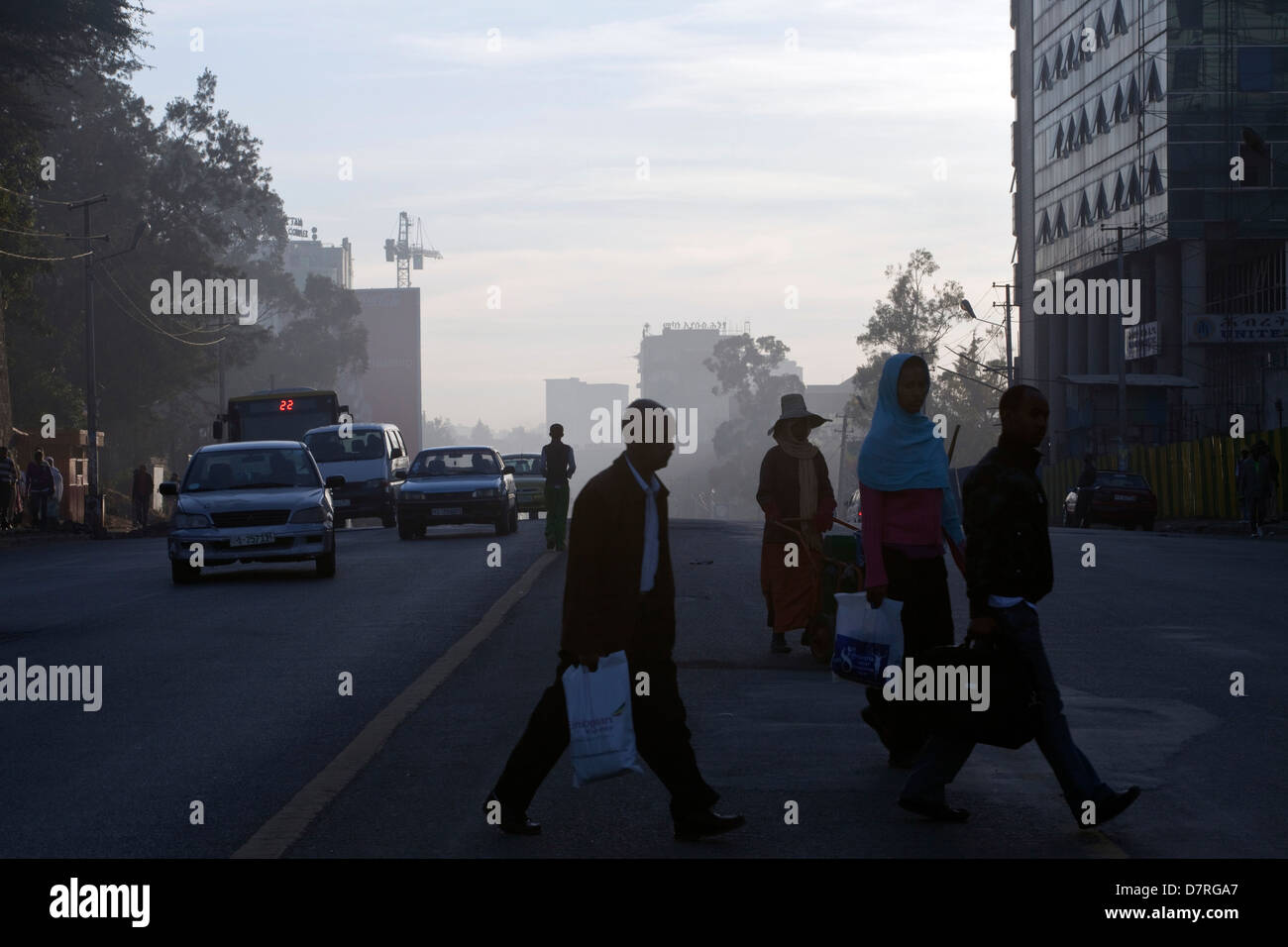 La gente che camminava per lavorare poco dopo l'alba attraverso il Meskel Square, Etiopia ad Addis Abeba. Foto Stock