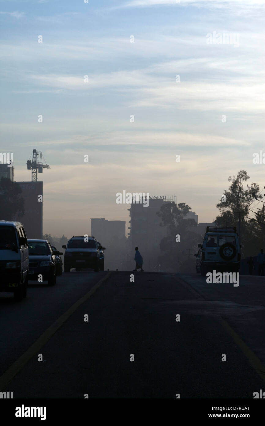 La gente che camminava per lavorare poco dopo l'alba attraverso il Meskel Square, Etiopia ad Addis Abeba. Foto Stock