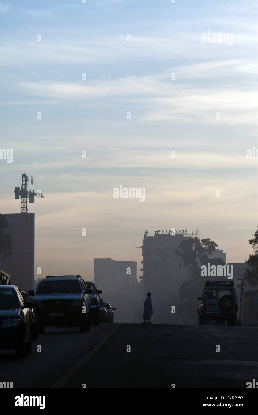 La gente che camminava per lavorare poco dopo l'alba attraverso il Meskel Square, Etiopia ad Addis Abeba. Foto Stock