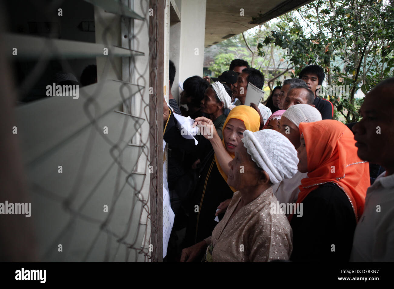 Talayan, Filippine, 13 maggio, 2013. Residenti filippini cercare i loro nomi nella lista degli elettori registrati durante lo svolgimento delle elezioni di medio termine nel sud della città filippina di Talayan a Maguindanao, 13 maggio 2013. Elezione nella regione segnata dalla violenza con sette morti e diversi feriti a livello nazionale. I militari hanno sollevato il red alert nella regione come la Commissione sulle elezioni deputati loro di fissare il processo politico. Credit:Jeoffrey Maitem /Alamy Live News Foto Stock