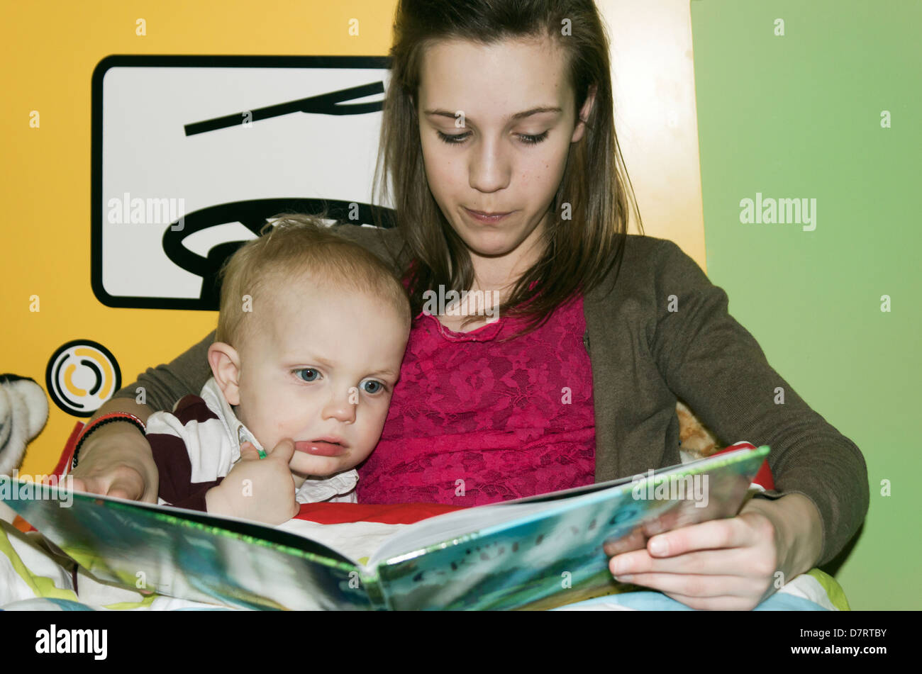 Ragazza giovane la lettura di una storia per un ragazzino. Foto Stock